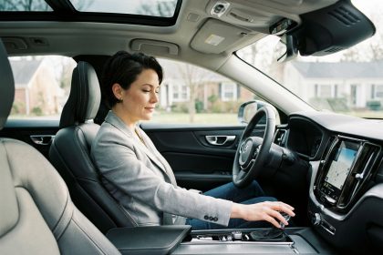 Femme au volant d'une voiture automatique en leasing, main posée sur le levier de vitesse, intérieur moderne